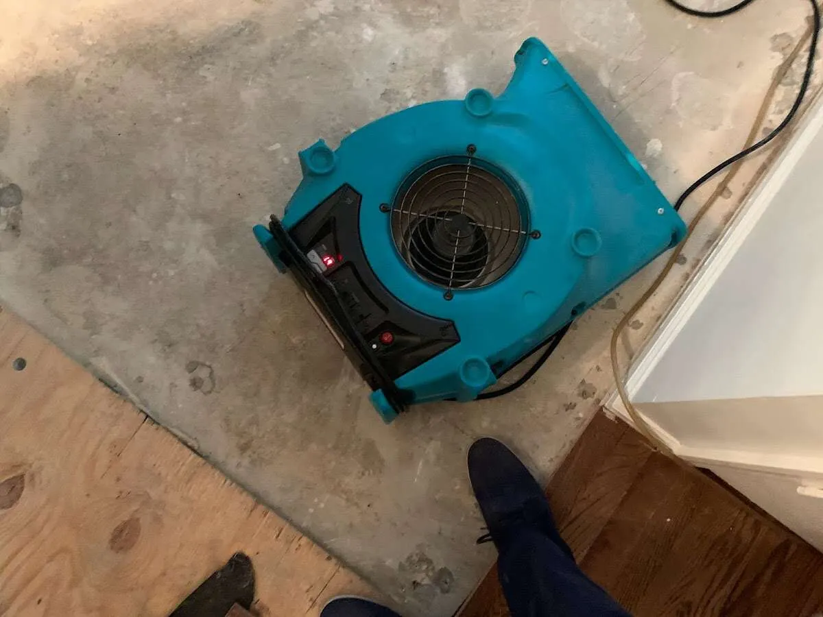 Air mover drying subfloor during Commercial Water Damage Restoration in Watford City